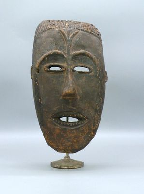 image d'un masque en bois sur un support sur fond blanc