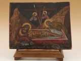 an old painting of jesus laying on the cross on a wooden stand