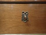 a wooden dresser with a metal knob on it