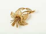 a close up of a gold brooch on a white surface