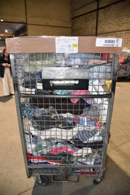 a metal cart with many items in it in a warehouse