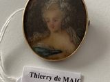 a miniature picture of a woman in a dress on display
