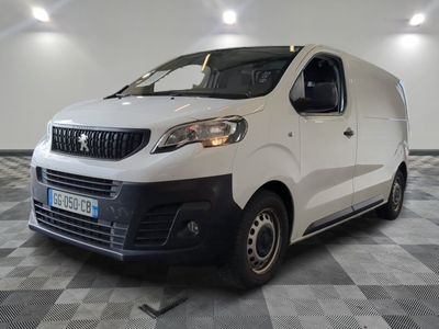 la camionnette blanche est garée dans une grande pièce au sol en damier