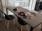 une table avec des chaises et un vase posé dessus, dans une pièce