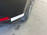 a black car parked in a garage with a license plate on it