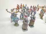 many figurines of different sizes and colors on a white surface
