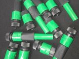 a close up of a bunch of green hoses on a black surface
