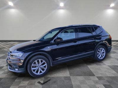 un SUV Volkswagen noir garé dans un garage au sol carrelé