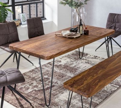 une table en bois avec des pieds en métal et un banc dans une pièce