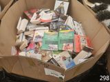 une boîte en carton remplie de livres et un chat allongé par terre