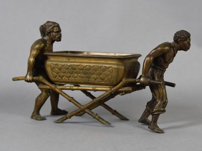 a bronze statue of two men pulling a tub