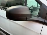 a side view of a white car with a brown side view mirror