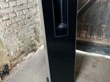 a black refrigerator sitting in front of a brick wall