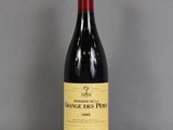 La bouteille de vin rouge est posée sur une table en verre.