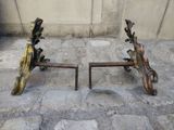two metal objects on the ground near a wall