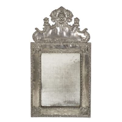 une image représentant un miroir à cadre argenté accroché à un mur blanc
