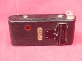 a black suitcase with a red button on it