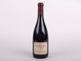 une bouteille de vin rouge posée sur une table blanche
