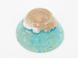 a small blue bowl with a brown top on a white surface