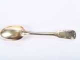 an antique silver spoon on a white surface with a white background