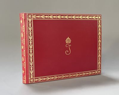 un vieux livre rouge aux tranches dorées, avec une couronne sur la couverture