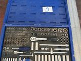 une boîte à outils bleue avec des outils sur le sol