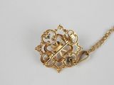 a close up of a gold necklace with a cross on it