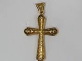 a gold cross pendant with a skull on it