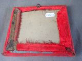 an old red picture frame with a tag on it sitting on a table