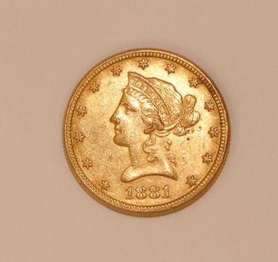 a close up of a gold coin with a woman ' s head on it