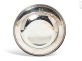 silver plate on white background with reflection of the bowl in the middle