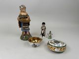 une figurine représentant un homme tenant un panier à côté d'un bol et une figurine représentant un homme