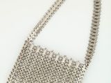 a close up of a silver purse on a white surface