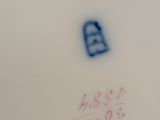 an image of a close up of a white plate with a blue number on it