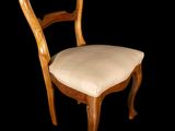 a wooden chair with a white seat and a black background