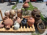 many vases sitting on a pallet in the yard