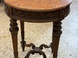 une petite table avec un plateau en marbre dans une pièce