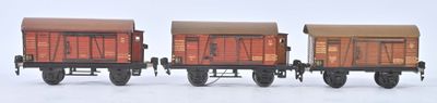 trois wagons de train miniature posés côte à côte sur une surface blanche