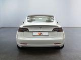 the back of a white tesla model s parked in a room