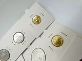 quatre types différents de pièces d'argent et d'or sur un fond blanc