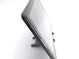 a tablet computer sitting on a stand on a white surface