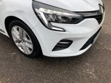the front end of a white car parked in a parking lot