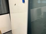 a white refrigerator with a blue handle in a room