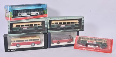 Trois maquettes de bus dans leur emballage sont posées les unes à côté des autres sur une table
