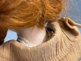 a doll with a red hair holding a cell phone