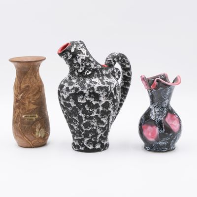trois vases posés l'un à côté de l'autre sur une surface blanche