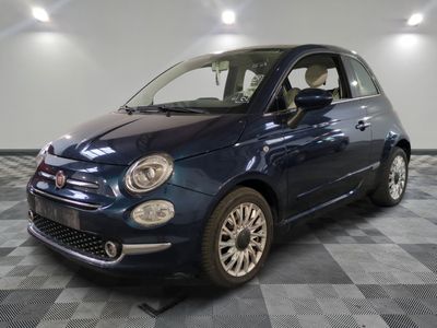 La petite voiture bleue est garée dans le garage, sur le sol à damier.