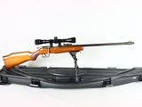 a rifle with a scope and a rifle stand on a white background