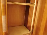a wooden closet with shelves and a toilet in it