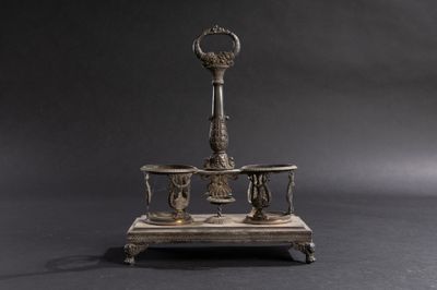 un bougeoir en argent surmonté d'une horloge